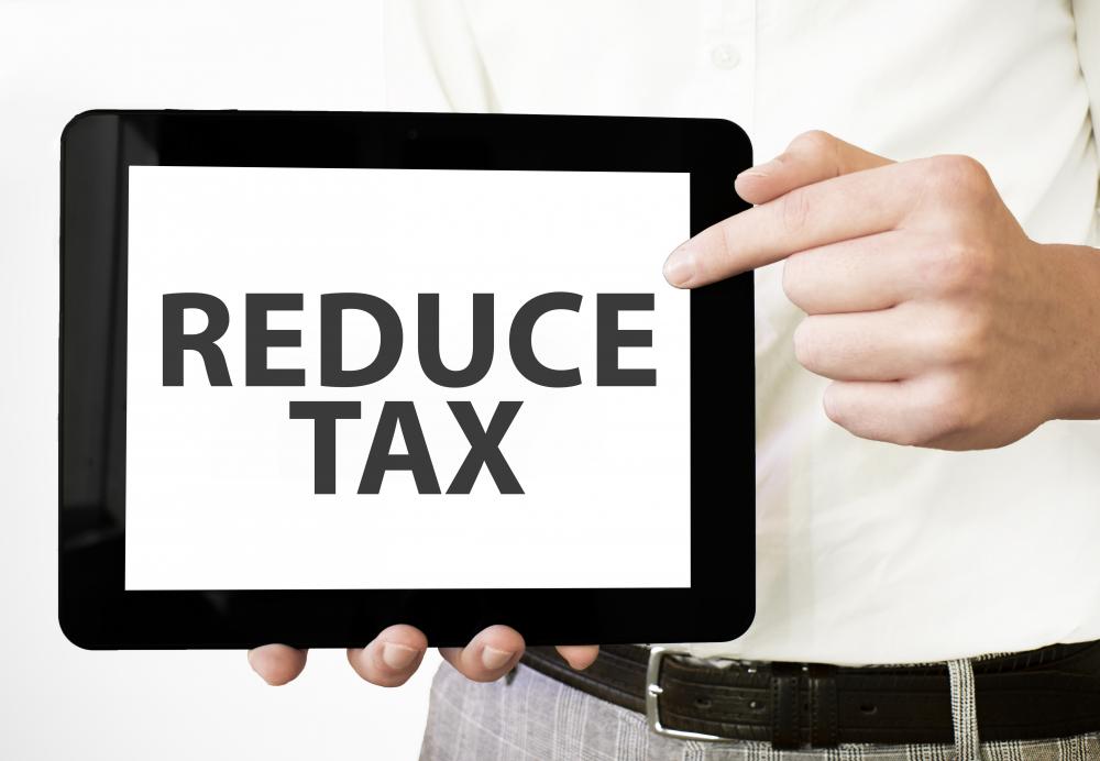 Businessman analyzing tax reduction on digital tablet